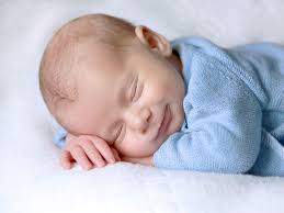 Gentle osteopathy for unsettled babies in Christchurch, showing a smiling baby lying on their tummy