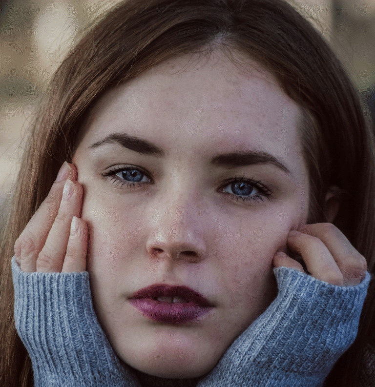 Woman holding head in hands due to jaw tension and teeth grinding in Christchurch